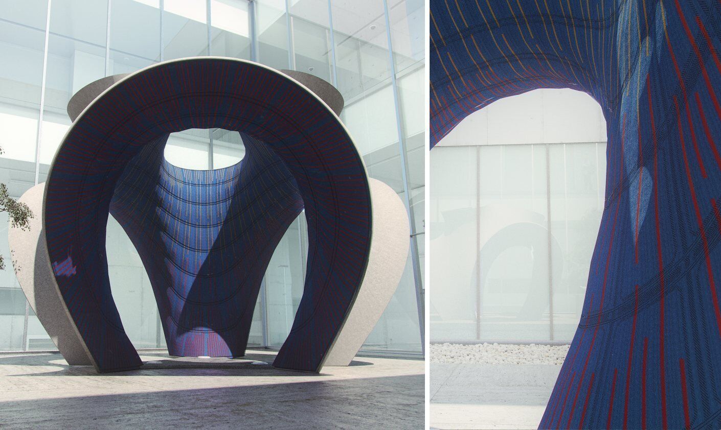 fabric pavilion with curved structural design in blue and red patterns