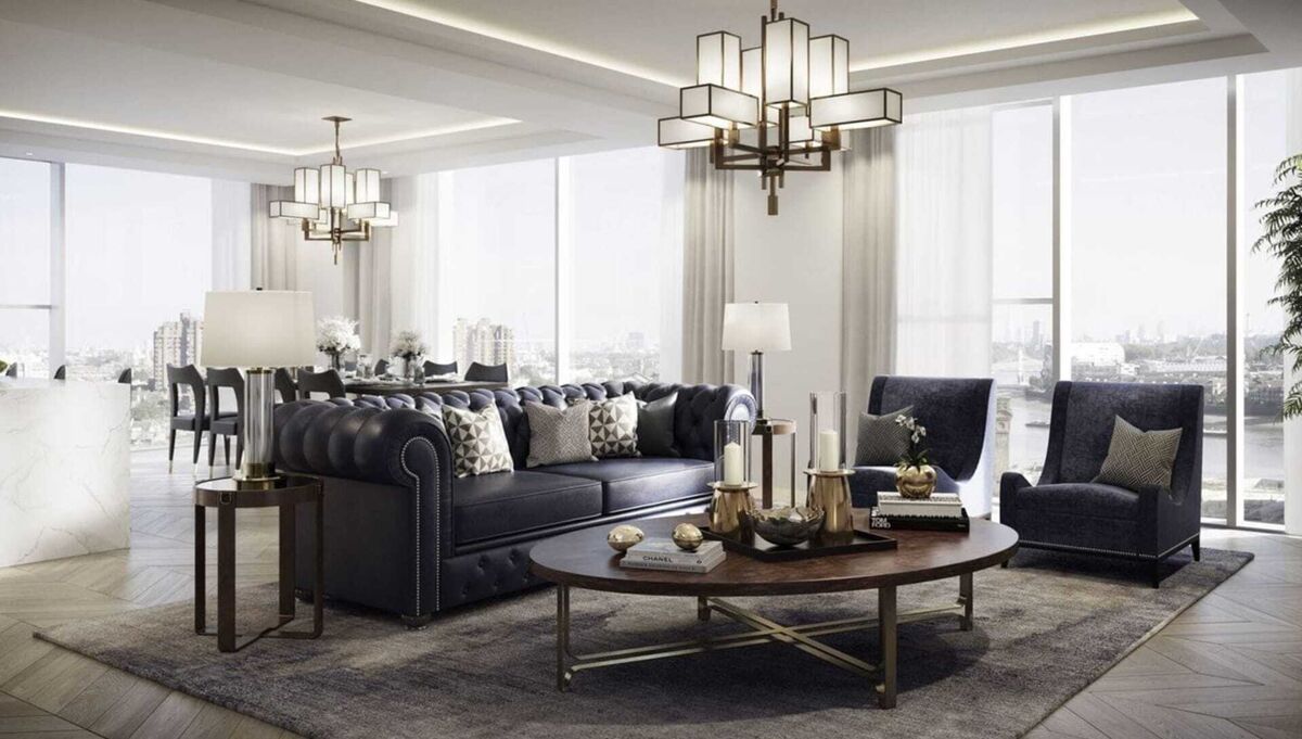 Elegant space with navy tufted sofa, armchairs, round coffee table, chandeliers, and city view windows.